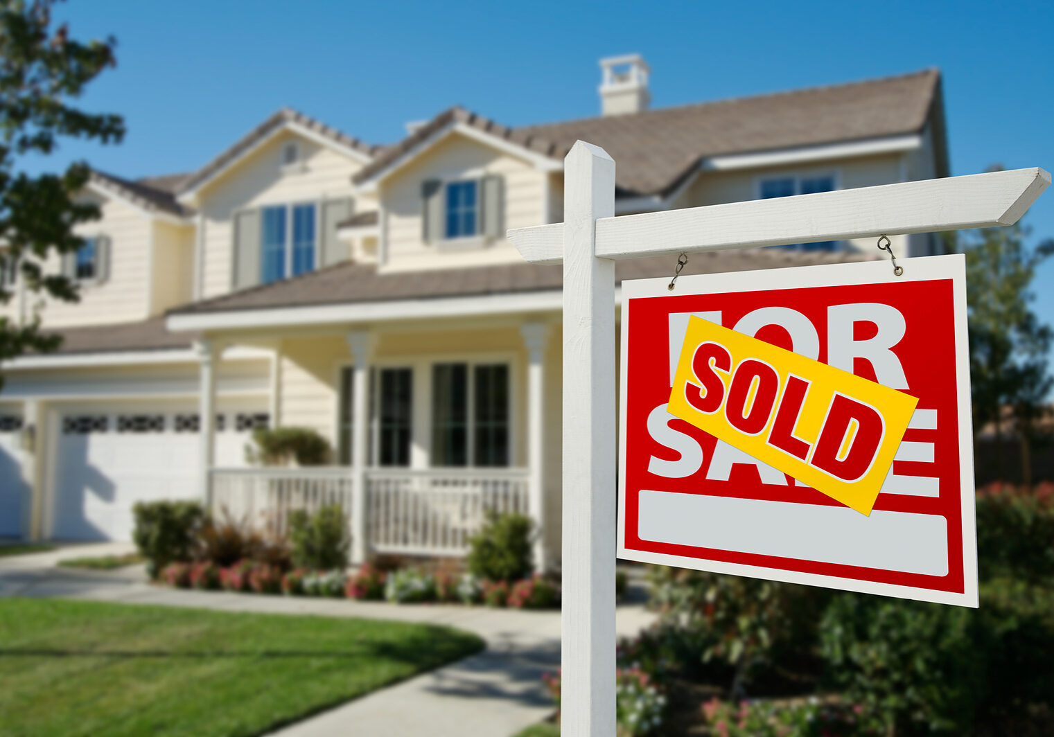 Sold Home For Sale Real Estate Sign in Front of New House. Sold Home For Sale Real Estate Sign in Front of New House.